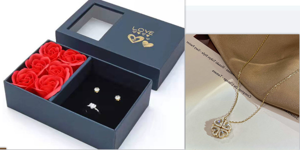 Gift box with small clover heart jewelry studs and red rose flowers