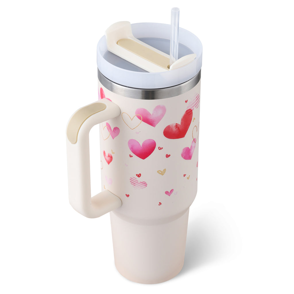 White insulated tumbler with heart print, handle, and clear straw in round lid