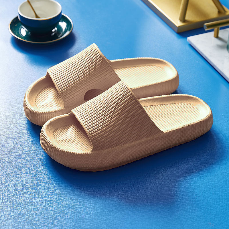 Beige cushioned slide slippers with open toe and textured strap.