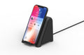 Small black wireless subwoofer speaker with phone on the dock and a connected cable