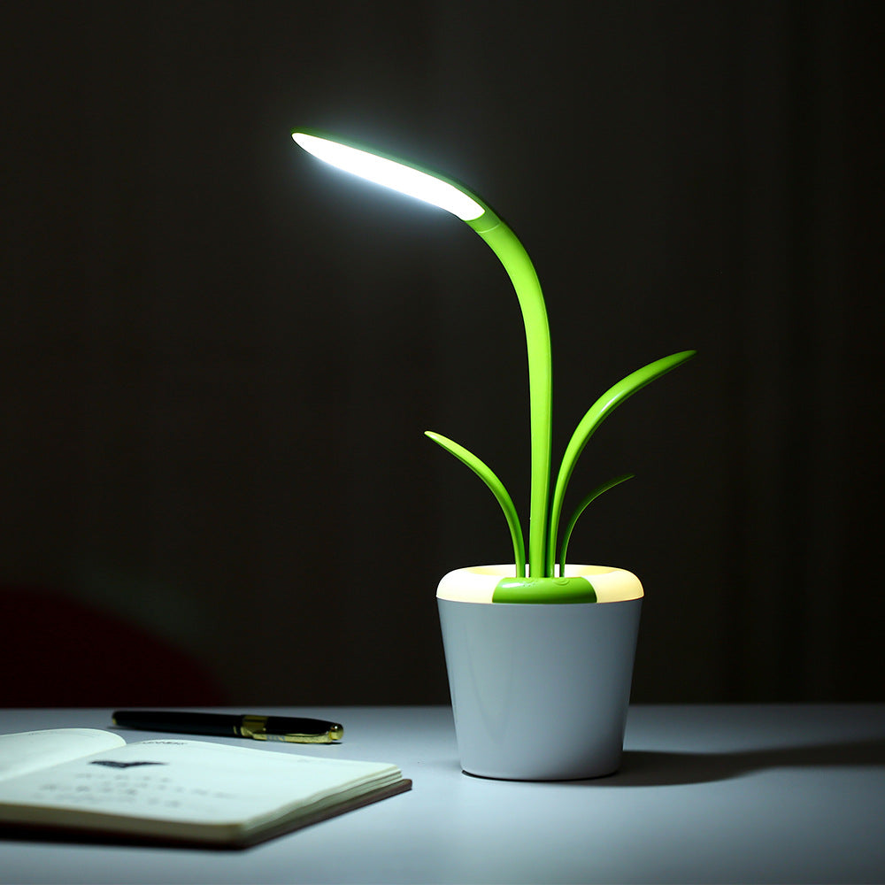 LED table lamp with glowing green stem and bright white pot; round base