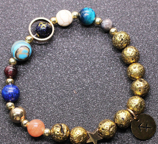 Gold beaded bracelet with blue, orange, and red stones and zodiac disc charms