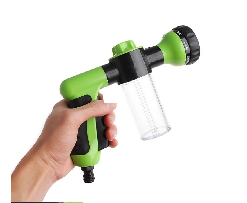Green and black foam spray gun with clear container bottle held in hand