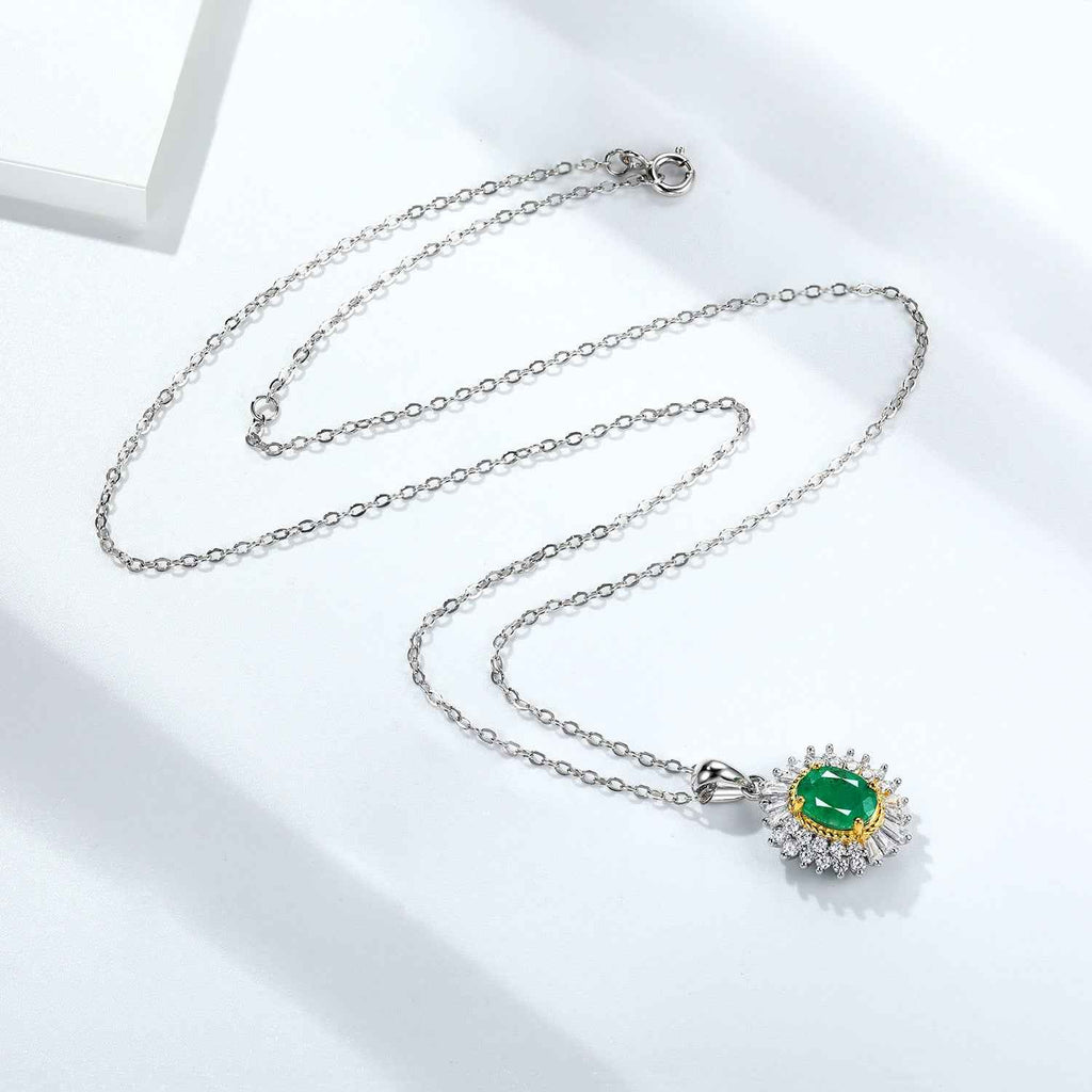 Oval green gemstone pendant necklace on silver chain with crystal halo and gold bezel