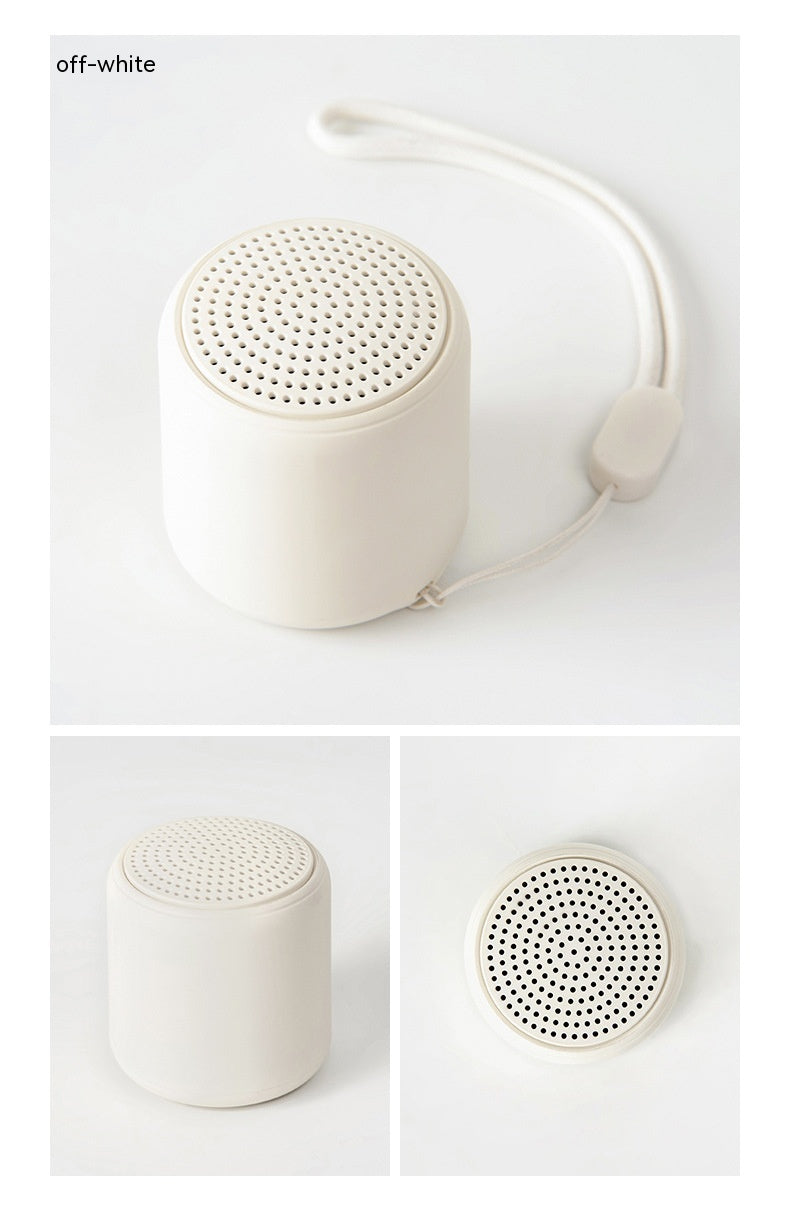 Portable wireless mini speaker, off-white cylinder with perforated top grille
