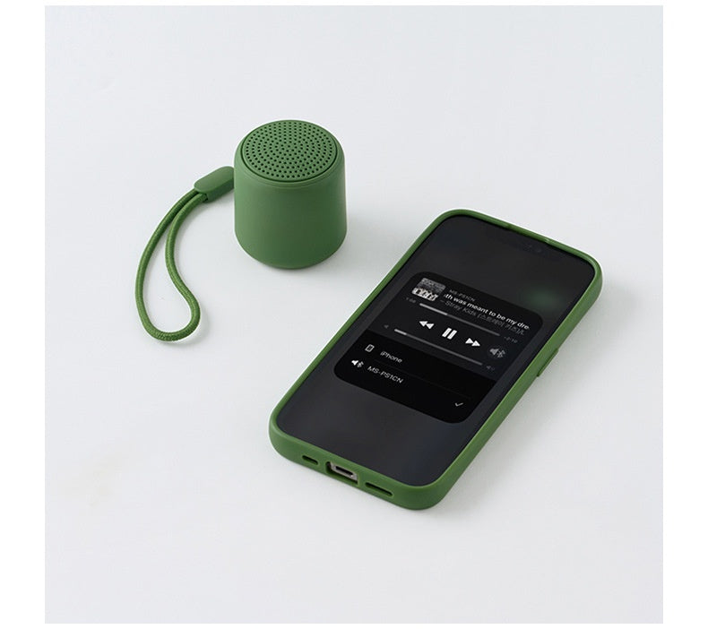 Portable wireless mini speaker, green cylinder with perforated top grille and side ports