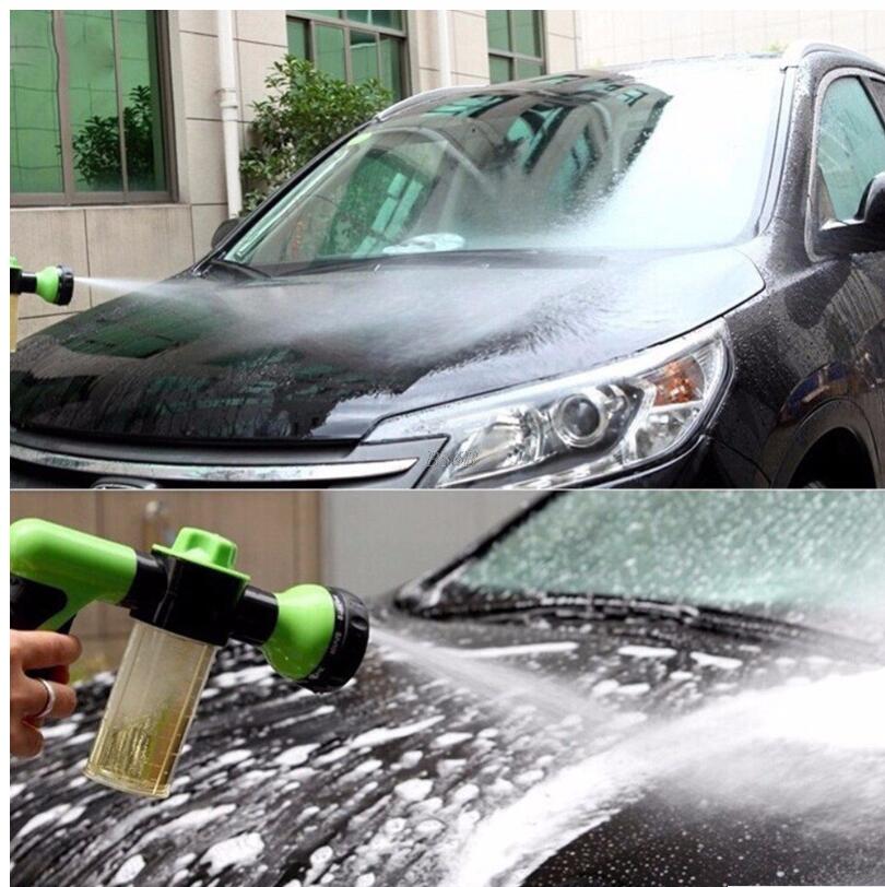 Green and black foam sprayer spraying onto a car hood with clear container