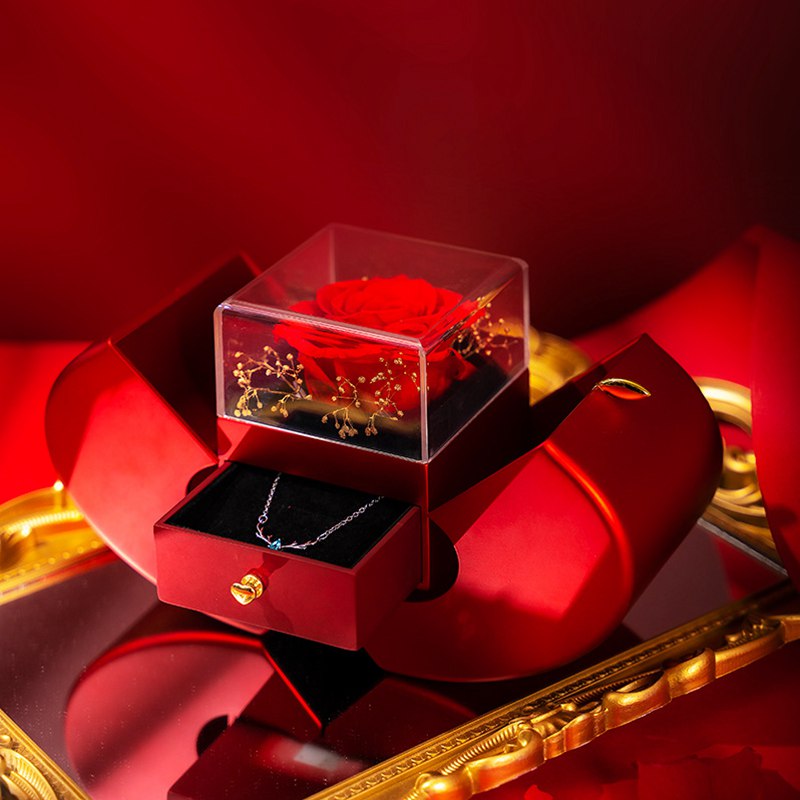 Red split jewelry box with clear rose cover, necklace chain, and dangling floral piece
