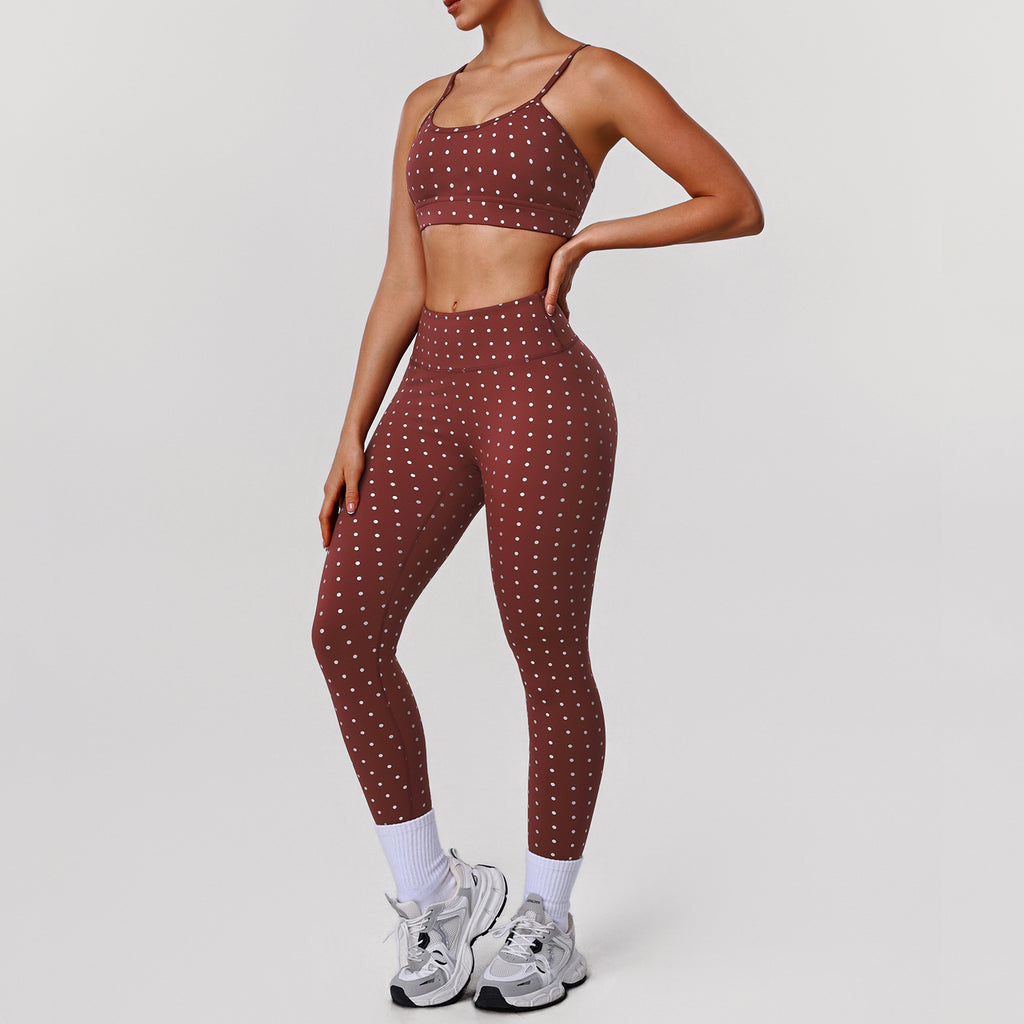 Women’s rust red sports bra and workout pants set with white dot print, side view