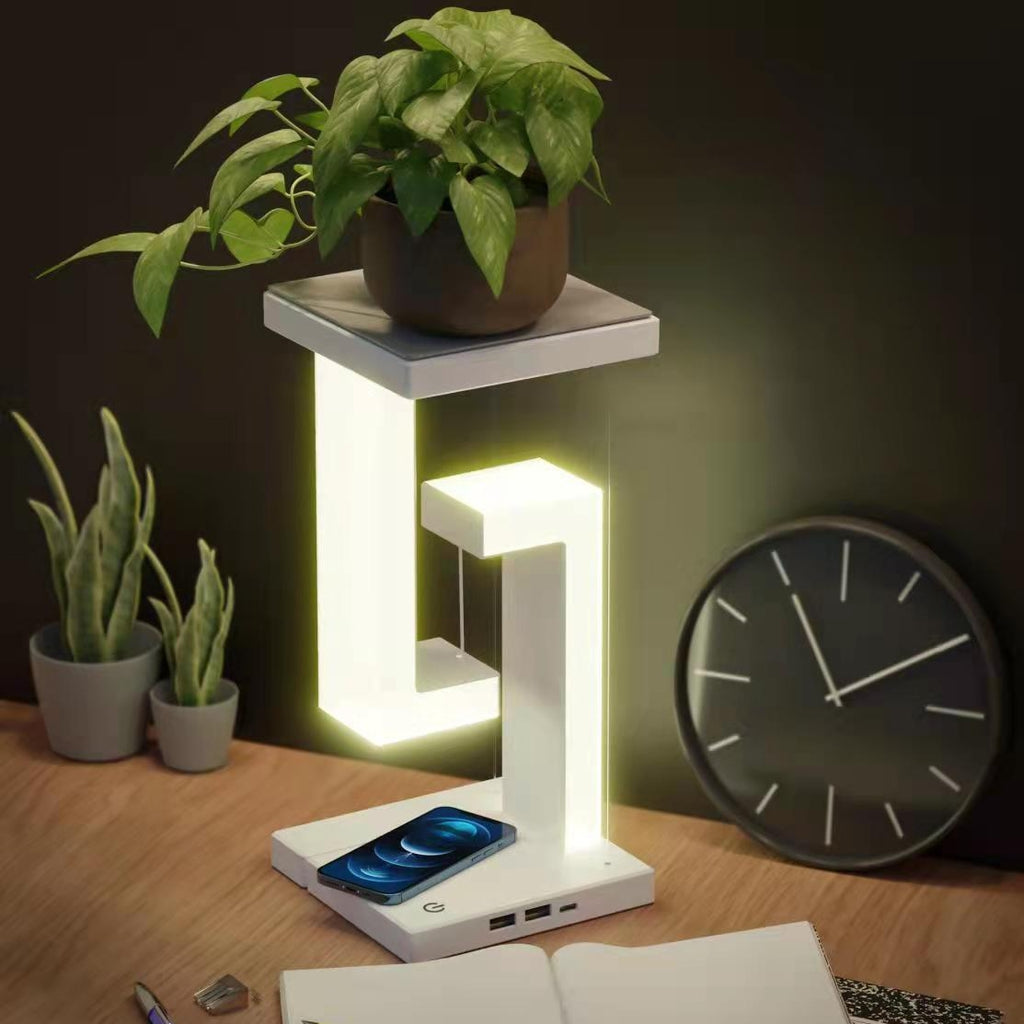 White wireless charging balance table lamp with glowing L-shaped light frame and phone base