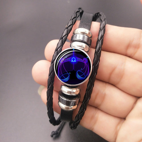 Black braided bracelet with round luminous zodiac charm and silver slider rings