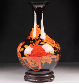 Ceramic vase with orange and red floral pattern, dark neck and pedestal base