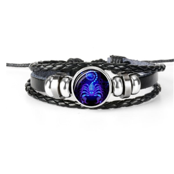 Braided leather-look bracelet with a large round luminous zodiac charm and curved metal segments.
