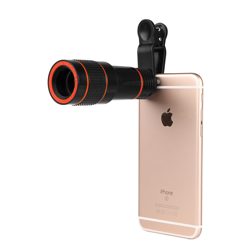 Black clip-on telescope camera lens on rose-gold smartphone with orange ring barrel