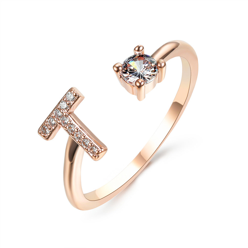 Rose gold adjustable initial ring with crossbar letter shape and round center stone.