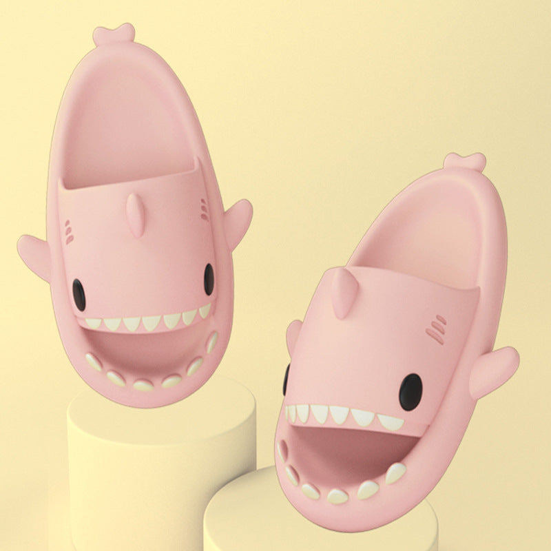 Cartoon shark slippers pair in pink, soft slide-on design with teeth detail