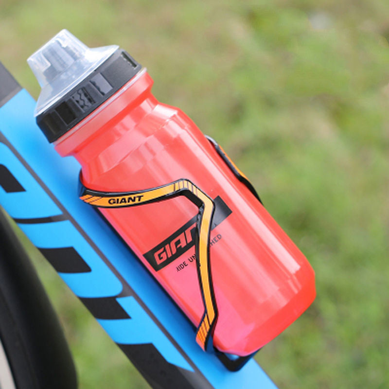 Red cycling water bottle with clear flip-top cap, mounted on blue bike frame