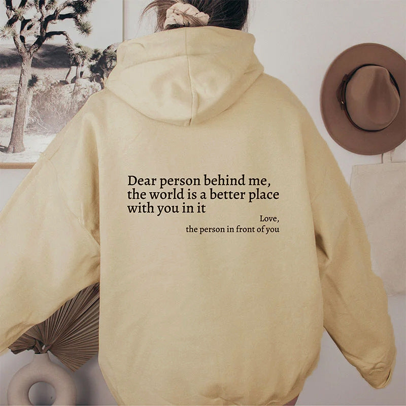 Cream plush hoodie with kangaroo pocket, drawstring hood, and centered letter print