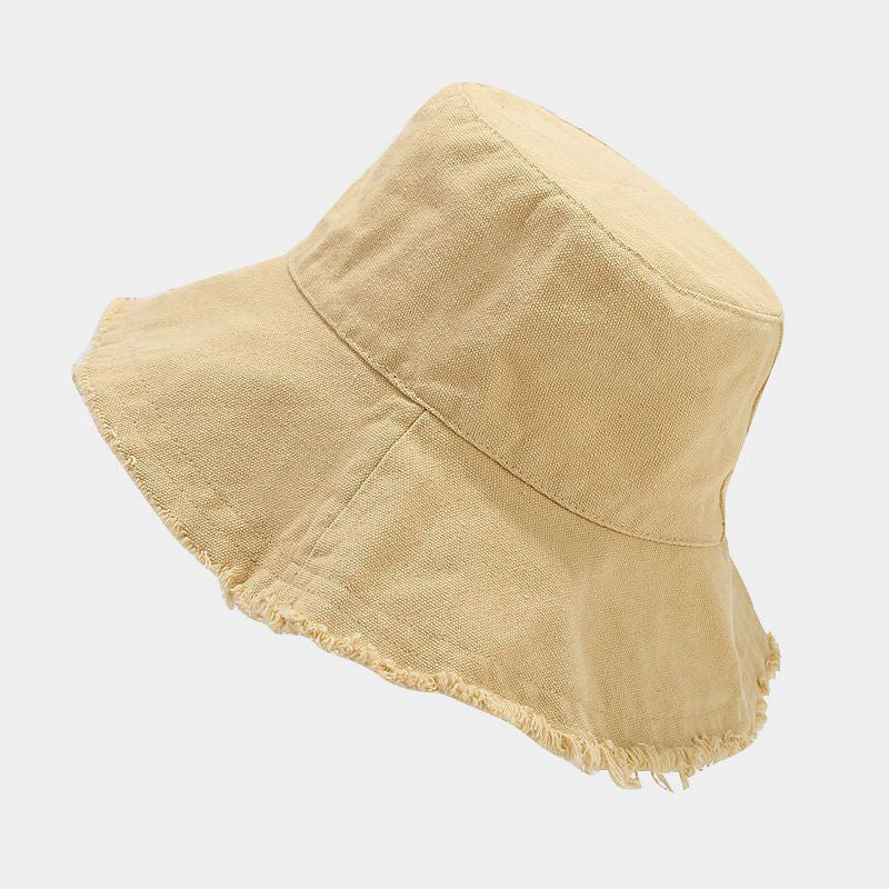 Tan sun hat with wide brim and frayed trim, softly textured fabric.