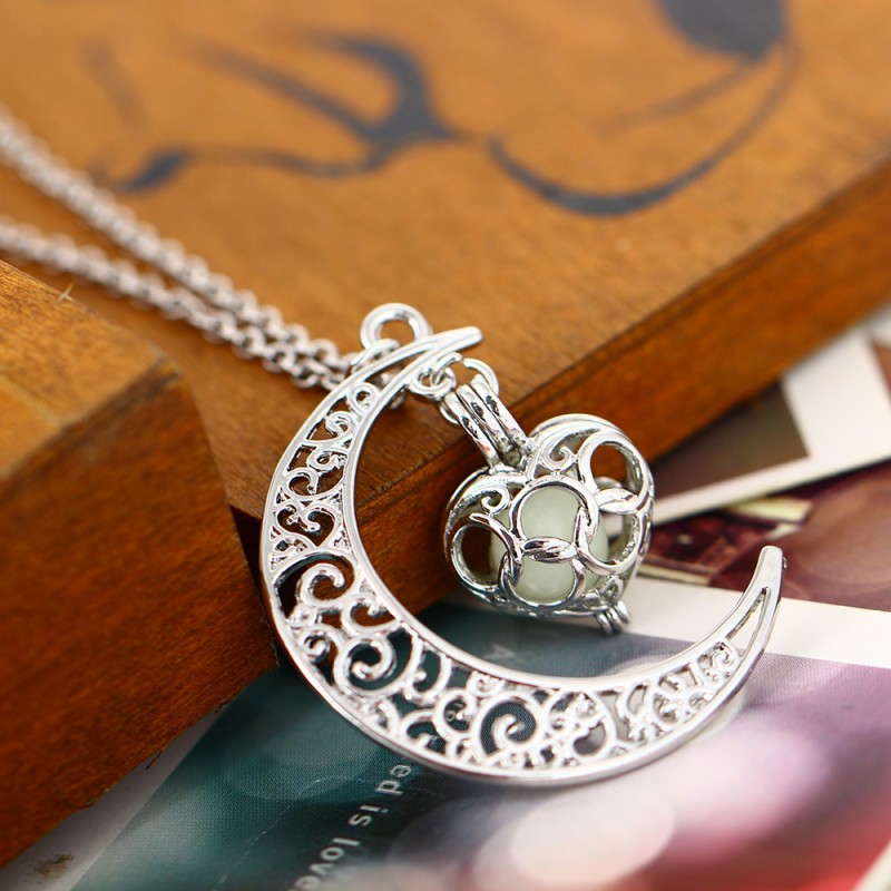 Silver filigree moon pendant with glowing blue cat and ornate ring bail