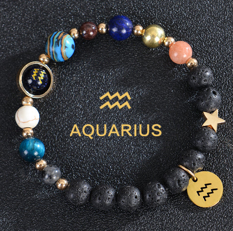 Zodiac bracelet with black lava beads and Aquarius charm, star and gold disc.