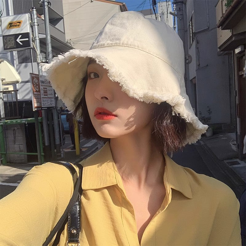 Cream sun hat with wide brim and soft frayed edge, curved crown.