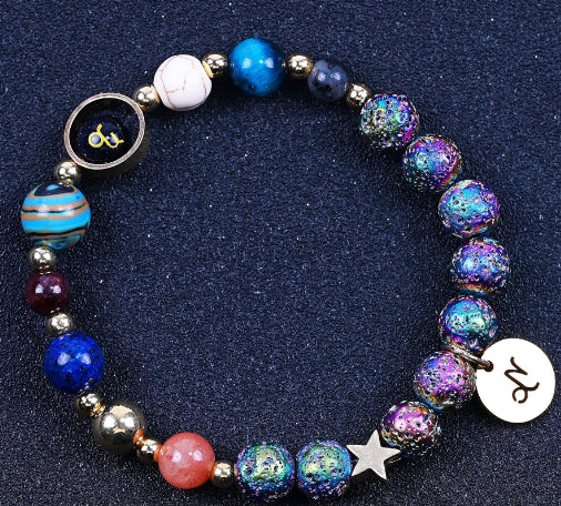 Beaded bracelet with blue lapis-like beads, purple glitter stones, star charm, zodiac charm disc.