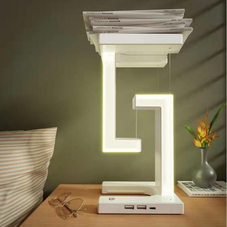 White wireless charging table lamp with tall glowing frame and phone charging dock