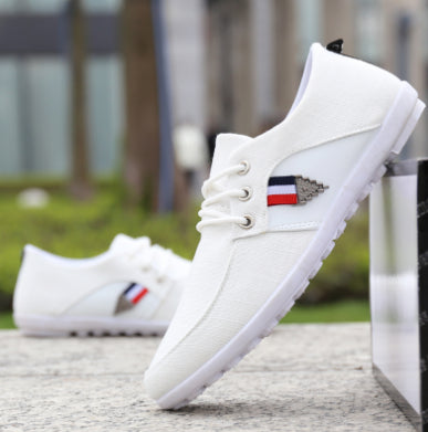 White canvas lace-up shoe with tricolor side logo and white rubber sole