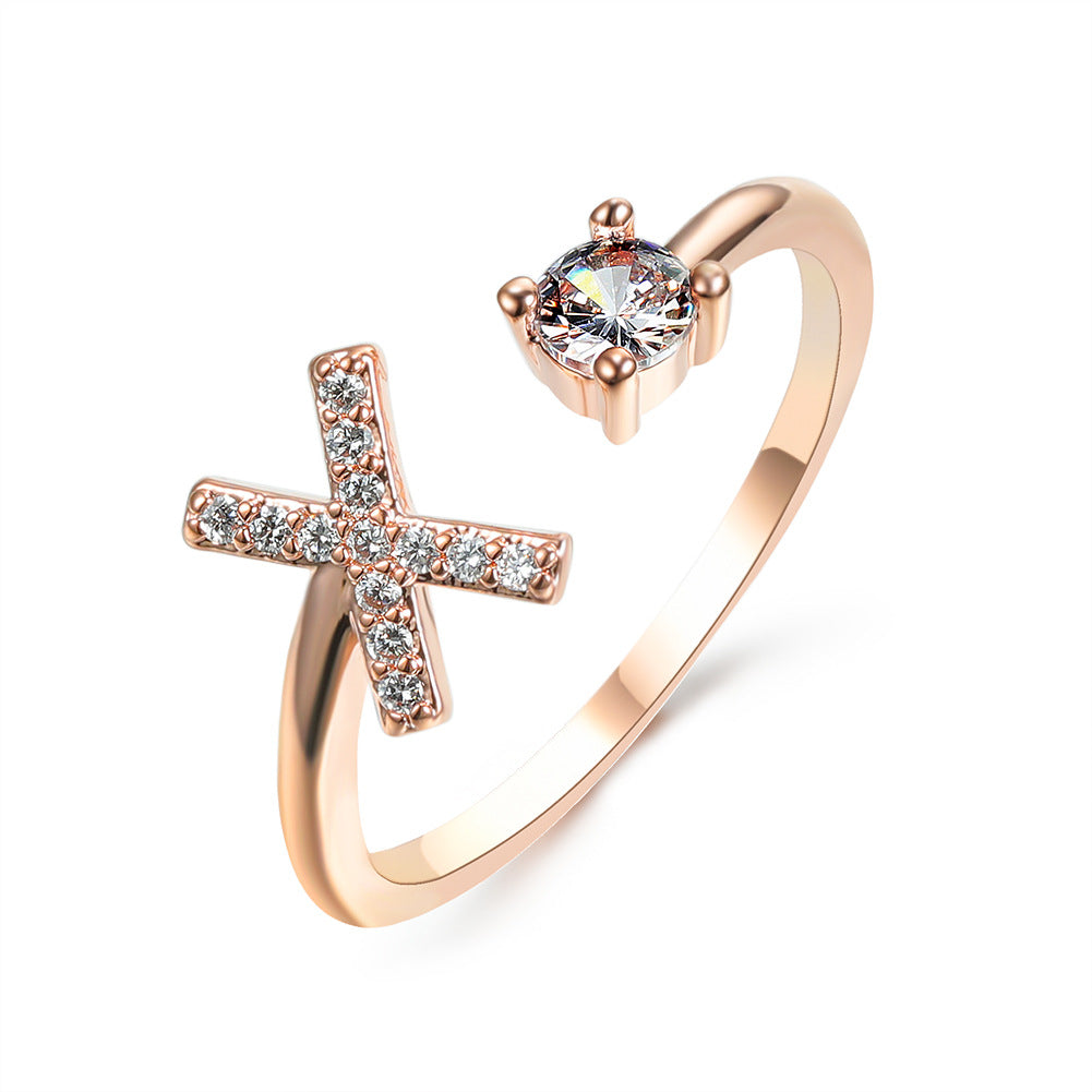 Rose gold adjustable initial ring with X-shaped letter and round center stone.