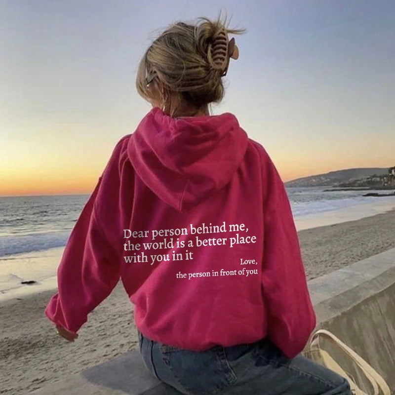 Fuchsia plush hoodie with hood, drawstrings, kangaroo pocket, and printed back message