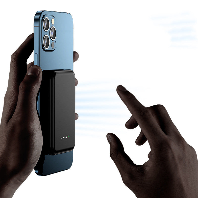 Blue and black magnetic wireless power bank in hand with charging indicator light