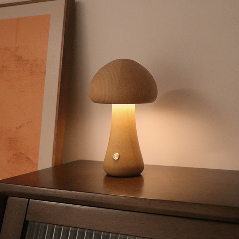 Light wooden mushroom LED night light on a cabinet shelf, glowing warm light