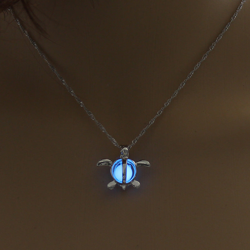 Silver lotus-like pendant necklace with glowing blue stone on a chain